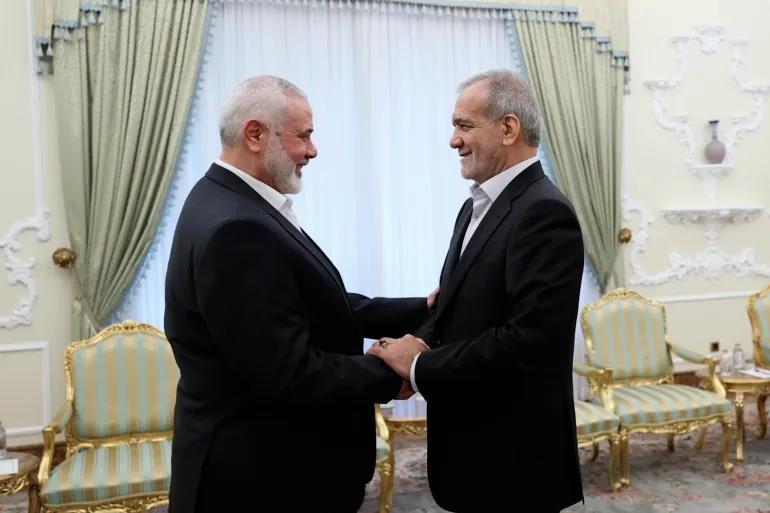 テヘランの大統領府で行われた会談の冒頭、ハマスのイスマイル・ハニェ議長と握手するペゼシュキアン大統領